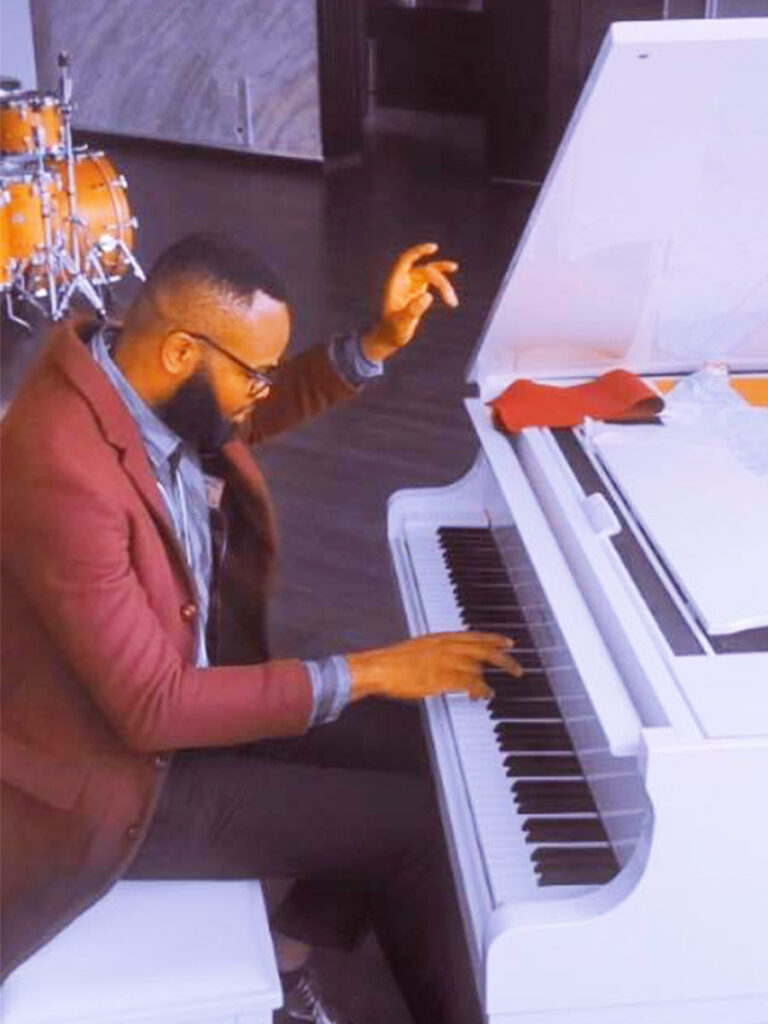 Innocent Okechukwu on a white piano